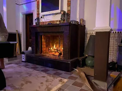 a fireplace in a room with a person standing in it at Suite avec salle de bain privée das un beau Riad avec piscine in Aghmat