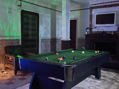 a pool table with balls on it in a room at Suite avec salle de bain privée das un beau Riad avec piscine in Aghmat