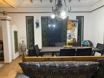 a dining room with a table and chairs at Suite avec salle de bain privée das un beau Riad avec piscine in Aghmat