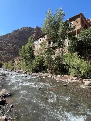 a river with a building on the side of a mountain at Gite Ifoulou Tassaout in Ifoulou