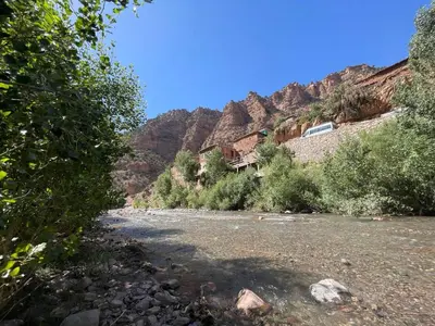 a river with a house on the side of a mountain at Gite Ifoulou Tassaout in Ifoulou