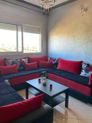a living room with red couches and a table at appart près du stade de fes in Fès