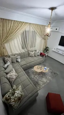 a living room with a couch and a table at A Comfortable & Modern Apartment Mhamid Marrakech in Oulad Akkou