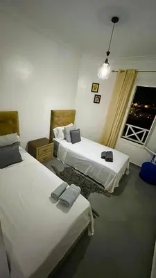 a hotel room with two beds and a window at A Comfortable & Modern Apartment Mhamid Marrakech in Oulad Akkou
