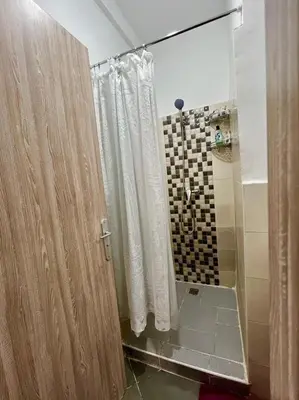 a bathroom with a shower with a shower curtain at A Comfortable & Modern Apartment Mhamid Marrakech in Oulad Akkou
