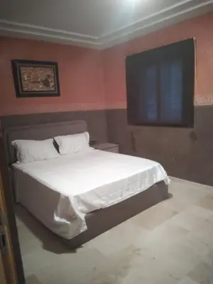 a bedroom with a bed and a flat screen tv at Villa Alhambra in Fès
