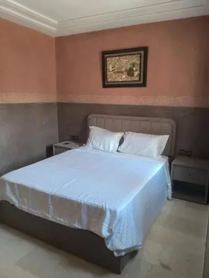 a bedroom with a large white bed in a room at Villa Alhambra in Fès