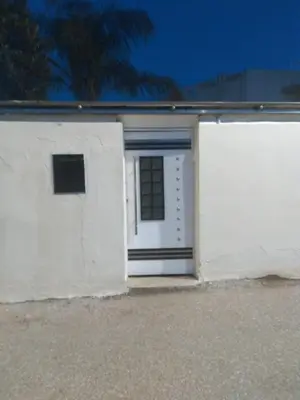 a white garage with a door and a window at Villa Alhambra in Fès