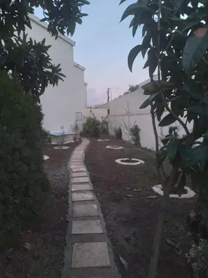 a stone path in a garden with a building at Villa Alhambra in Fès