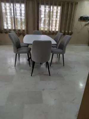 a table and chairs in a large room with windows at Villa Alhambra in Fès