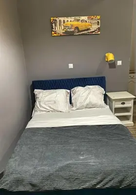 a bed with a blue headboard in a bedroom at Moussa in Oulad Akkou
