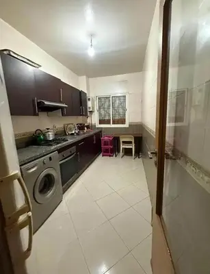 a kitchen with a sink and a washing machine at Moussa in Oulad Akkou