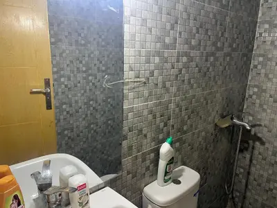 a bathroom with a shower and a toilet with a mirror at Luxe University Apartment 1 in Fès