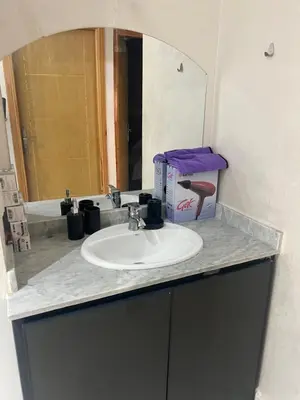 a bathroom counter with a sink and a mirror at Luxe University Apartment 1 in Fès