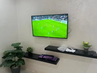 a television on a wall with a soccer game on it at Luxe University Apartment 1 in Fès