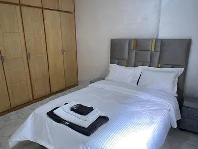a bedroom with a white bed with a robe on it at Luxe University Apartment 1 in Fès