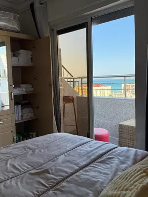 a bedroom with a bed and a view of the ocean at Snensnsnsnsnhxbeb in Oulad Akkou