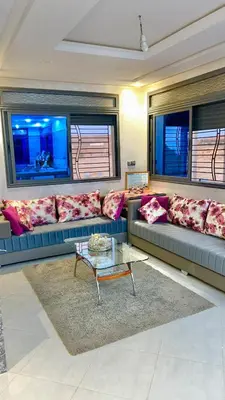 a living room with a couch and a table at Havre de paix à la campagne in El Hajeb