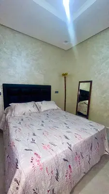 a bedroom with a large bed with a pink blanket at Havre de paix à la campagne in El Hajeb