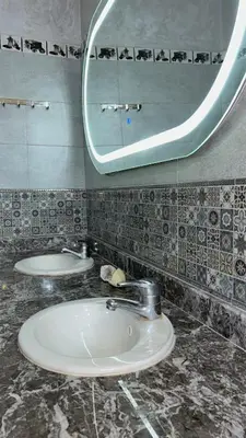 a bathroom with two sinks and a mirror at Havre de paix à la campagne in El Hajeb