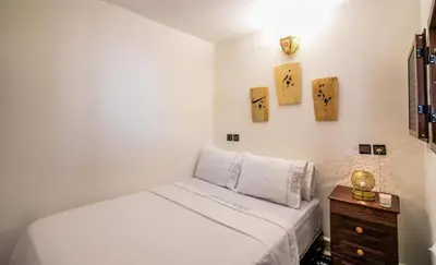 a bedroom with a bed and a dresser with a night stand at Dar Yanis in Fès