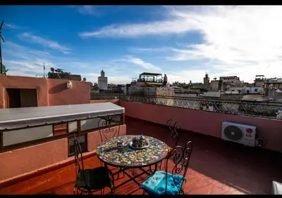 a balcony with a table and chairs on a roof at Dar Yanis in Fès
