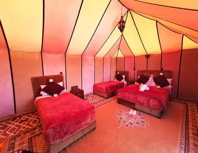 a room with two beds in a tent at Nomad Haven Luxury Camp in Merzouga