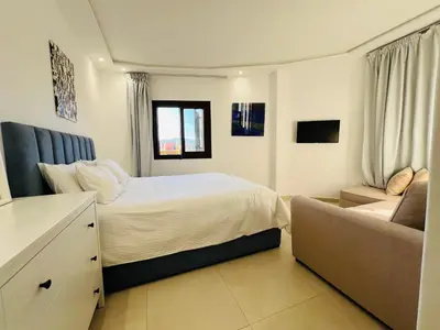 a bedroom with a bed and a couch at Colina Smir par Immo Marina Vacances de Rêve D2-4 in Oulad Akkou