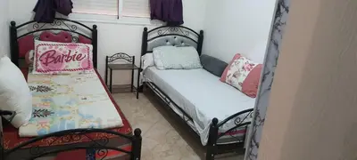 a bedroom with two twin beds and a window at Modern Furnished Apartment in Imouzzer Kandar