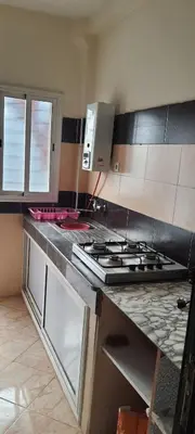 a kitchen with a stove and a counter top at Modern Furnished Apartment in Imouzzer Kandar