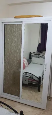 a small bedroom with a bed inside of a glass door at Modern Furnished Apartment in Imouzzer Kandar
