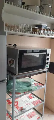 a microwave oven on a shelf in a kitchen at Modern Furnished Apartment in Imouzzer Kandar