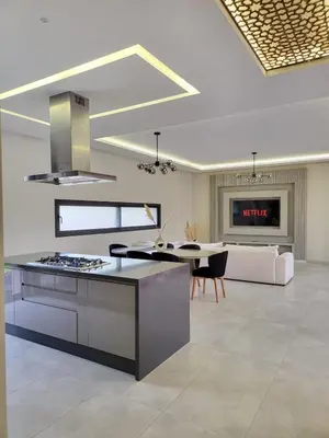 a kitchen and living room with a stove and a couch at Villa Madjeyalia Soft Luxury in Marrakech
