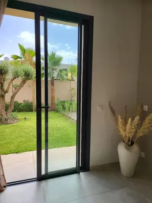 an open glass door with a vase with a plant at Villa Madjeyalia Soft Luxury in Marrakech