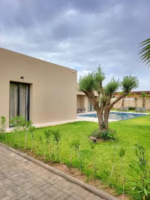 a house with a tree in the middle of a yard at Villa Madjeyalia Soft Luxury in Marrakech