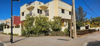 a white building with a balcony on a street at Atlas stay in Fès