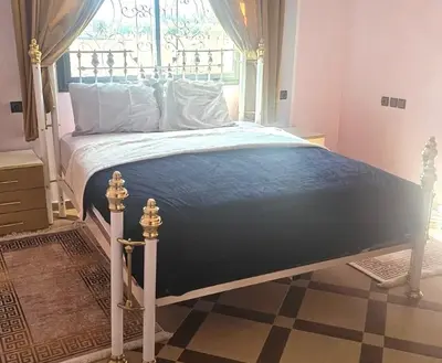 a bedroom with a bed with a blue comforter and a window at Atlas stay in Fès