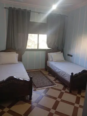 two beds sitting in a room with a window at Atlas stay in Fès