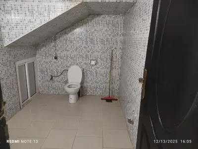 a bathroom with a toilet in a tiled wall at Studio riad zitouna in Meknès