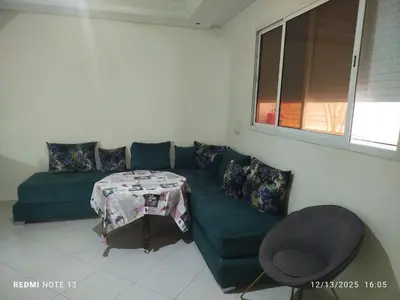 a living room with a green couch and a table at Studio riad zitouna in Meknès