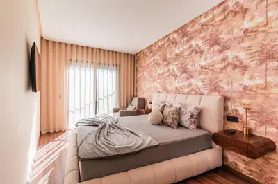 a bedroom with a large bed and a couch at Urban Pearl Refined and bright in Oulad Akkou