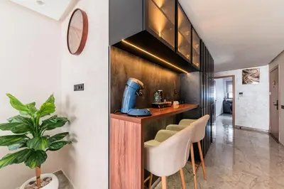 a kitchen with a bar with stools at Urban Pearl Refined and bright in Oulad Akkou