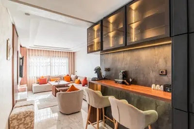 a kitchen and living room with a couch at Urban Pearl Refined and bright in Oulad Akkou