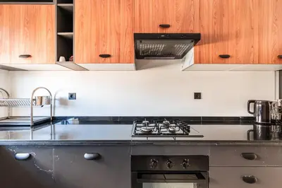 a kitchen with a sink and a stove top oven at Urban Pearl Refined and bright in Oulad Akkou