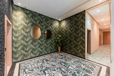 a hallway with a green and white patterned wall at Urban Pearl Refined and bright in Oulad Akkou