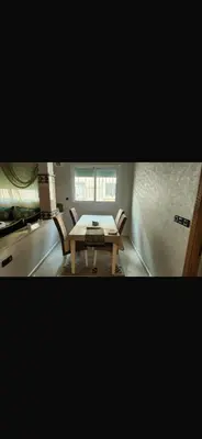 a kitchen with a table and chairs in a room at Spacious apartment in Fès