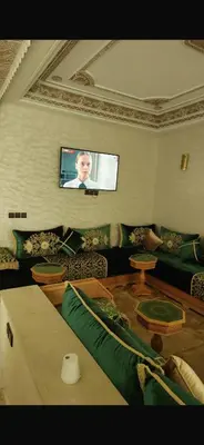 a living room with a couch and a flat screen tv at Spacious apartment in Fès