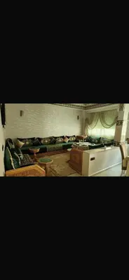 a living room with couches and a table at Spacious apartment in Fès