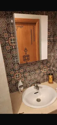 a bathroom sink with a mirror on a wall at Spacious apartment in Fès