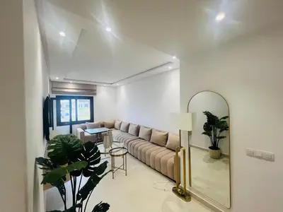 a living room with a couch and a mirror at Colina Smir par Immo Marina Vacances de Rêve D1-3 in Oulad Akkou